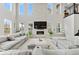 Spacious living room featuring a cozy fireplace, soaring ceilings, and large windows for ample natural light at 6614 S Vandriver Way, Aurora, CO 80016
