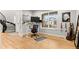 Bright home office with a large window, light wood floors, desk, and spiral staircase at 6614 S Vandriver Way, Aurora, CO 80016