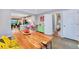Open concept dining area with a large wood table and colorful decor at 2530 S Knox Ct, Denver, CO 80219