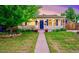Charming home featuring a covered porch, blue door, and well-manicured lawn at 2530 S Knox Ct, Denver, CO 80219