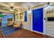 Inviting front porch with seating area, blue door and decorative lighting at 2530 S Knox Ct, Denver, CO 80219