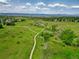 Scenic aerial view of a park with meandering paths, green spaces, and distant mountains at 2011 Sundrop Trl, Highlands Ranch, CO 80126