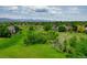 Expansive aerial view of a residential area with green fields and scattered homes and green trees at 2011 Sundrop Trl, Highlands Ranch, CO 80126