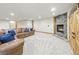 Basement living room with leather couch, stone fireplace, and white carpet at 2011 Sundrop Trl, Highlands Ranch, CO 80126