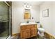 Bathroom with modern shower, wood vanity, and neutral colors at 2011 Sundrop Trl, Highlands Ranch, CO 80126