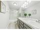 Bright bathroom features a double vanity, shower, and modern fixtures and finishes at 2011 Sundrop Trl, Highlands Ranch, CO 80126