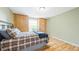 Bedroom featuring hardwood floors, a window providing natural light, and wood paneling at 2011 Sundrop Trl, Highlands Ranch, CO 80126
