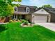 Charming home featuring a lush front lawn, beautiful landscaping, and a cozy front porch at 2011 Sundrop Trl, Highlands Ranch, CO 80126