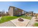 Green backyard with fire pit, pergola, and well-manicured lawn at 261 Mesa Ave, Lochbuie, CO 80603