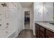 Bathroom featuring a bathtub and shower combo, wood cabinets, and a large walk-in closet at 261 Mesa Ave, Lochbuie, CO 80603