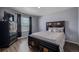 Bedroom features wood floors, a large bed, a chest of drawers, and a window with blinds at 261 Mesa Ave, Lochbuie, CO 80603