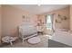 Bright Bedroom features a white crib, rocking chair, and soft decor at 261 Mesa Ave, Lochbuie, CO 80603