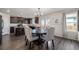Dining area featuring a dark wood table with neutral upholstered chairs and an adjacent kitchen at 261 Mesa Ave, Lochbuie, CO 80603