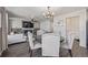Open concept living space with dining area featuring neutral upholstered chairs and dark wood table at 261 Mesa Ave, Lochbuie, CO 80603