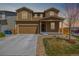 Inviting two-story home boasts a covered front porch, attached garage, and well-maintained landscaping at 261 Mesa Ave, Lochbuie, CO 80603