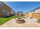 Stone fire pit in a landscaped backyard with a pergola in the distance at 261 Mesa Ave, Lochbuie, CO 80603