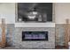 Stone accent wall with an electric fireplace and decorative elements at 261 Mesa Ave, Lochbuie, CO 80603