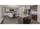 Open-concept kitchen and dining area with dark wood cabinets, granite countertops, and stainless steel appliances at 261 Mesa Ave, Lochbuie, CO 80603