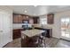 This kitchen boasts dark cabinets, granite countertops, stainless appliances and an island with seating at 261 Mesa Ave, Lochbuie, CO 80603