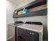 Modern laundry room with gray washer and dryer and shelving at 261 Mesa Ave, Lochbuie, CO 80603