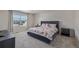 A spacious carpeted primary bedroom has a queen-size bed, two bedside tables, and a view from the window at 261 Mesa Ave, Lochbuie, CO 80603