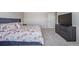 Primary bedroom with plush carpet has a dresser, a queen bed with floral pattern linens, and neutral paint at 261 Mesa Ave, Lochbuie, CO 80603