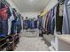 Walk-in closet features built-in shelving and is full of clothes, shoes, and handbags at 261 Mesa Ave, Lochbuie, CO 80603