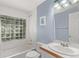 Bathroom with tiled walls, glass block window, and blue accent wall at 10345 Lions Heart, Lone Tree, CO 80124