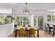 Stylish dining room features modern lighting, natural light, wood floors, and provides access to outdoor deck and kitchen at 10345 Lions Heart, Lone Tree, CO 80124