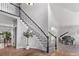 Elegant foyer showcases a grand staircase with wrought iron railings, hardwood floors, and a piano in the living space at 10345 Lions Heart, Lone Tree, CO 80124