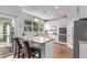 Bright kitchen features white cabinetry, granite countertops, and a breakfast bar overlooking the lush outdoor scenery at 10345 Lions Heart, Lone Tree, CO 80124