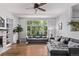 Bright and airy living room featuring a cozy fireplace, built-in shelving, hardwood floors, and large windows providing backyard views at 10345 Lions Heart, Lone Tree, CO 80124