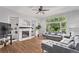 Inviting living room featuring a cozy fireplace, built-in shelving, hardwood floors, and large windows providing backyard views at 10345 Lions Heart, Lone Tree, CO 80124