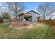 Landscaped backyard featuring a retaining wall, lush lawn, and a shed at 16273 E Prentice Pl, Centennial, CO 80015