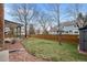 Backyard featuring mature trees, green grass, wooden fence and landscaping with brick borders at 16273 E Prentice Pl, Centennial, CO 80015