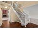 Elegant foyer showcasing a staircase with decorative iron railings and hardwood floors leading to the living area at 16273 E Prentice Pl, Centennial, CO 80015