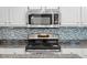 Updated kitchen featuring modern appliances, granite counters, and blue tile backsplash at 16273 E Prentice Pl, Centennial, CO 80015