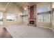 Open living room with a brick fireplace and an adjoining view into the bright kitchen at 16273 E Prentice Pl, Centennial, CO 80015