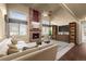Warm living room features a cozy brick fireplace, vaulted ceilings, and plenty of natural light at 16273 E Prentice Pl, Centennial, CO 80015