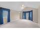 Large main bedroom featuring vaulted ceilings, carpet floors, and bright windows with elegant blue curtains at 16273 E Prentice Pl, Centennial, CO 80015