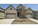 Inviting home featuring a stone facade, tandem three-car garage, and contemporary architectural details at 2924 S Poppy St, Morrison, CO 80465