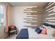 Stylish bedroom with a unique wood accent wall, comfortable bed, and a charming accent chair at 9305 S Gore St # C, Arvada, CO 80007