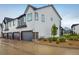 Townhome exterior featuring attached garages, neutral siding, and manicured landscaping at 9305 S Gore St # C, Arvada, CO 80007