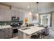 Open kitchen featuring stainless steel appliances, a center island, and trendy pendant lighting at 9305 S Gore St # C, Arvada, CO 80007