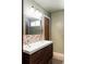 Bathroom with double sink vanity, dark wood cabinets, and decorative mirror at 3820 S Fraser St, Aurora, CO 80014
