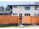 Two-story townhouse exterior with a brown trim and a bright orange fence with a gate leading to front door at 3820 S Fraser St, Aurora, CO 80014