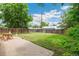 Backyard featuring a brick patio, green lawn, mature trees, and wooden fencing at 4142 Chase St, Denver, CO 80212