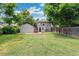 Large backyard with lush green lawn, detached garage, patio area, and wooden fence at 4142 Chase St, Denver, CO 80212