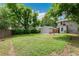Spacious backyard with a lush green lawn, detached garage, and patio area at 4142 Chase St, Denver, CO 80212
