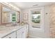Bathroom with a marble countertop vanity, large mirror, and window with a view at 4142 Chase St, Denver, CO 80212
